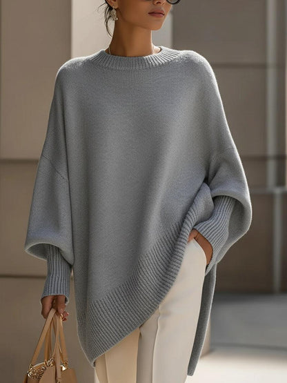 Dam poncho i olivgrön med moderna fladdermousärmar och draperad siluett